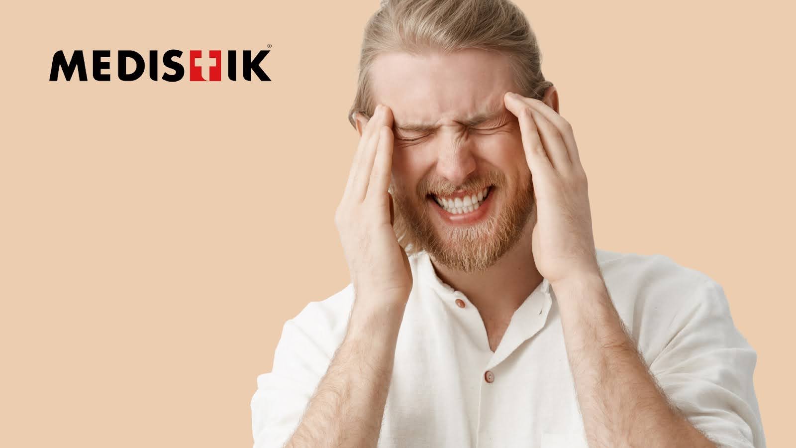 A person clutches their head, experiencing a migraine, looking for instant migraine relief at home.