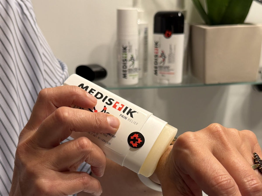 MEDISTIK Power Stick pressed on the wrist, bathroom shelf with the Power Trio behind
