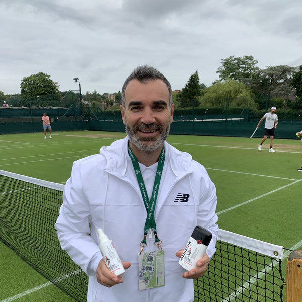 A physiotherapist at Wimbledon holding the Power Spray and Power Stick
